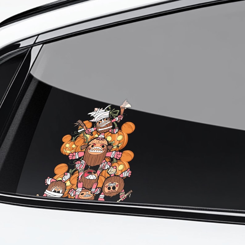 May include: A colorful Halloween-themed car decal featuring a stack of cartoon monsters and pumpkins. The monsters have various expressions and are wrapped in bandages. The pumpkins are orange with carved faces. The decal is displayed on a car window.