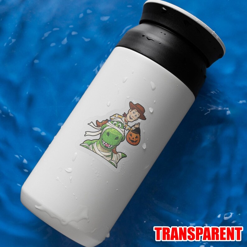 May include: White insulated water bottle with a black lid. A sticker features Woody and Rex from Toy Story in Halloween costumes. Woody is holding a pumpkin bucket, and Rex is wrapped in bandages. The word "TRANSPARENT" is at the bottom.