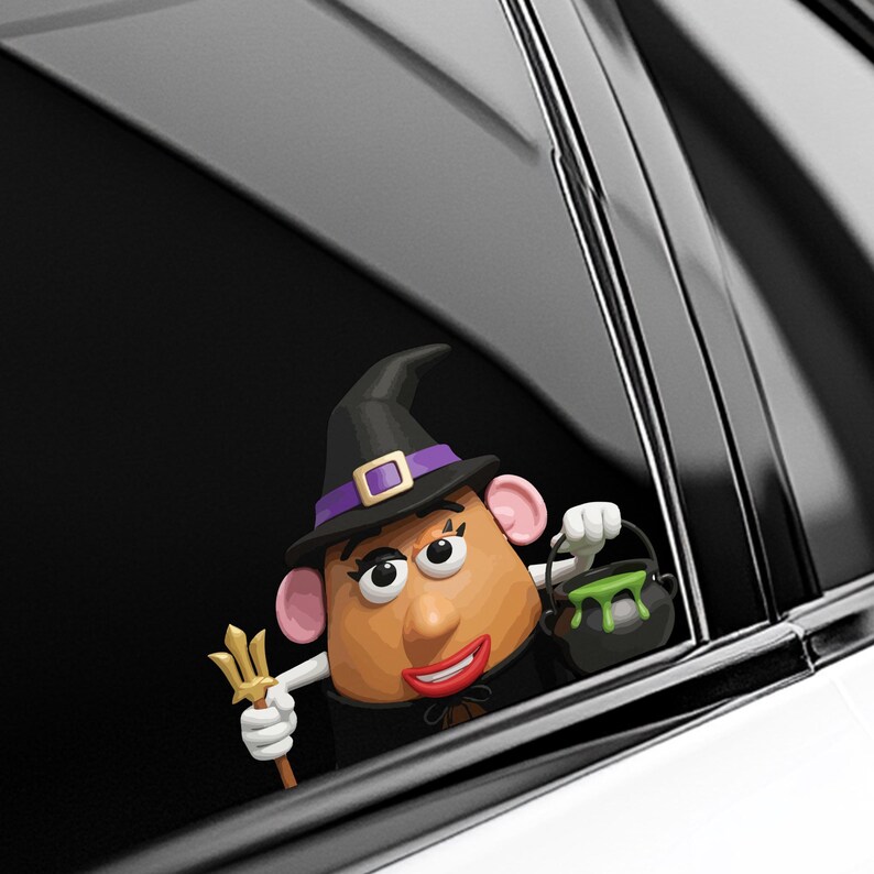 May include: A whimsical Halloween-themed car decal featuring a potato-shaped character dressed as a witch. The character wears a black hat with a purple band and holds a trident and a cauldron with green liquid. The decal is set against a car window.