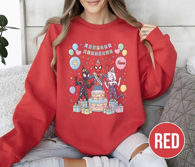 May include: A red sweatshirt featuring a colorful graphic of Spider-Man characters celebrating a birthday. The design includes a cake, balloons, and the words "Happy Birthday". The number "4" is also displayed.