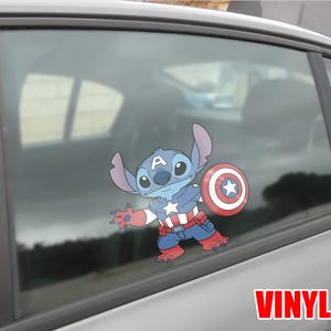 May include: A blue and red vinyl decal of Stitch dressed as Captain America, holding a shield with a star. The decal is applied to a car window. The word "VINYL" is printed in red.