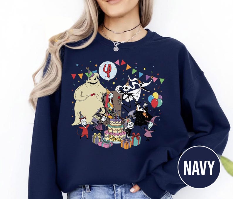 May include: Navy blue sweatshirt featuring a colorful graphic of characters from The Nightmare Before Christmas celebrating a birthday. The design includes a birthday cake, presents, and the number 4. The word "NAME" is also visible.