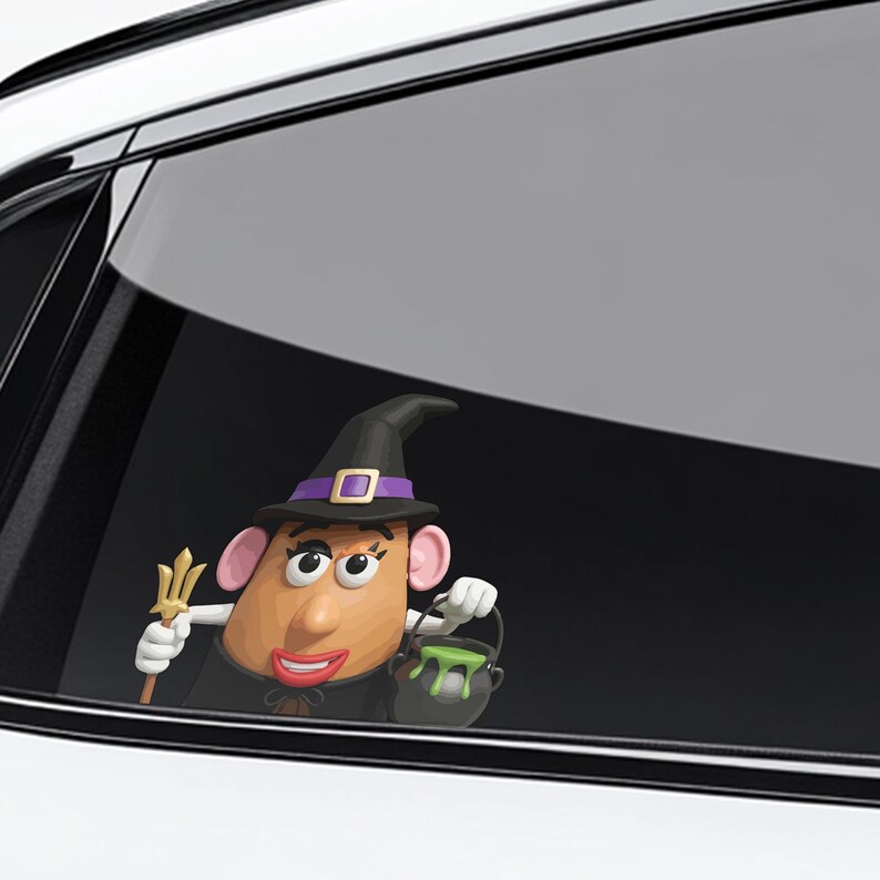 May include: A Halloween-themed car window decal featuring a cartoon potato character dressed as a witch. The character wears a black hat with a purple band, a black cape, and holds a trident and a cauldron with green slime.