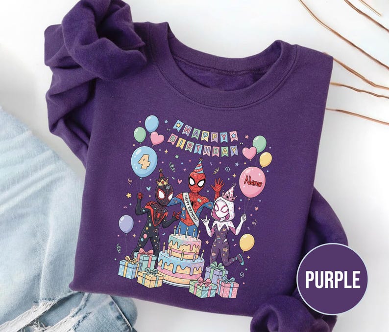 May include: Purple sweatshirt featuring a colorful graphic of Spider-Man characters celebrating a birthday. The design includes a cake, balloons, and the text "Happy Birthday". The number "4" is also displayed.
