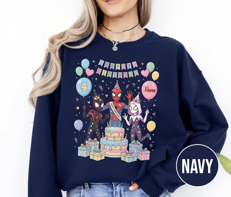 May include: Navy blue sweatshirt featuring a colorful graphic of Spider-Man characters celebrating a birthday. The design includes a cake, balloons, and the text "HAPPY BIRTHDAY" and "4". The word "Name" is on a balloon. The sweatshirt is a comfortable, casual style.