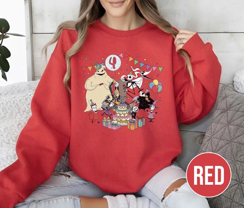 May include: Red sweatshirt featuring a colorful graphic of characters from The Nightmare Before Christmas celebrating a birthday. The design includes Jack Skellington, Sally, and Oogie Boogie around a cake, with the number 4. The word "RED" is in a red circle.