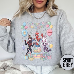May include: Sport grey sweatshirt featuring a colorful birthday design with Spider-Man characters, balloons, a cake, and the text "Happy Birthday". The number "4" is on a balloon. Presents are at the bottom.