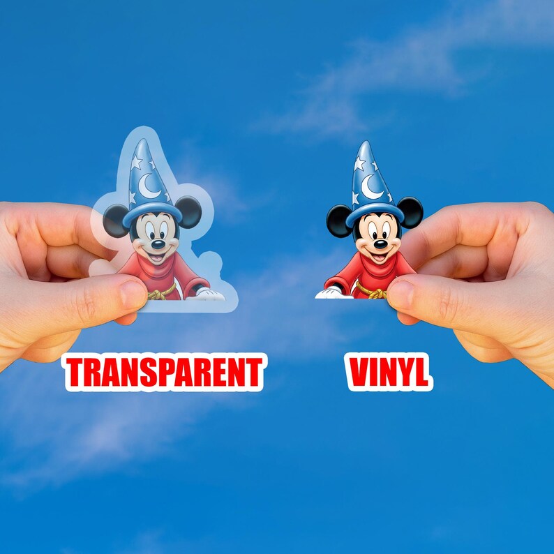 May include: Two Mickey Mouse stickers are held up against a blue sky. One is transparent, the other is vinyl. Both stickers feature Mickey in a red robe and a blue wizard hat with a crescent moon and stars. The word "TRANSPARENT" is below the first sticker, and "VINYL" is below the second.