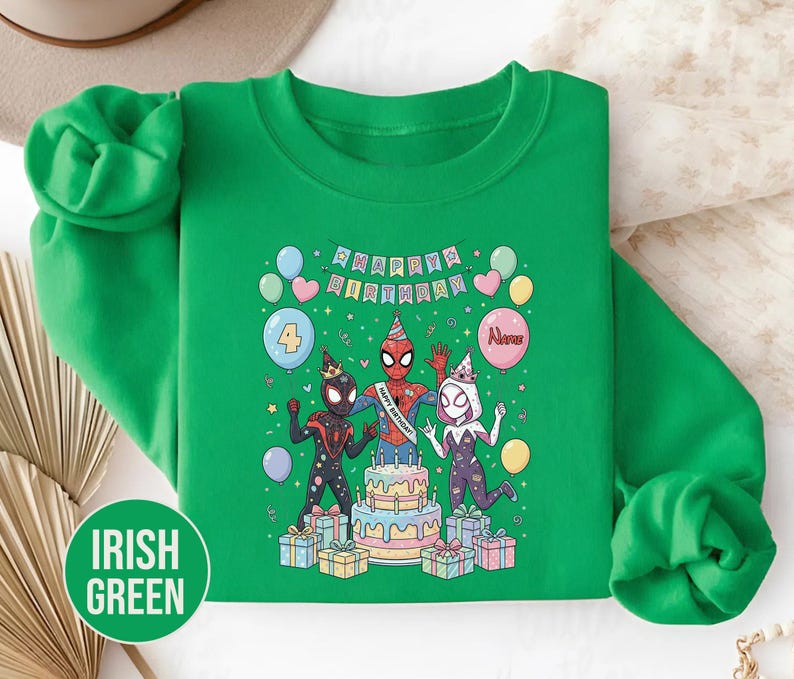 May include: Irish green sweatshirt featuring a colorful graphic of Spider-Man characters celebrating a birthday. The design includes a cake, balloons, and the text "Happy Birthday". The number 4 is on a balloon, and the name "Alexis" is on another.