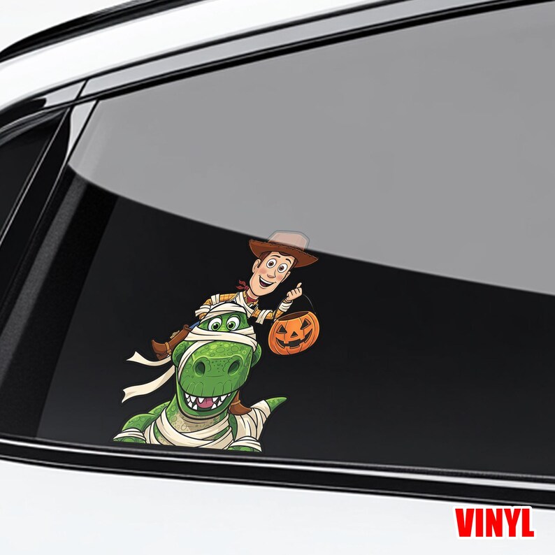 May include: A colorful vinyl decal featuring a cartoon image of Woody from Toy Story riding a green dinosaur wrapped in bandages, holding a jack-o'-lantern. The word "VINYL" is printed in red at the bottom.