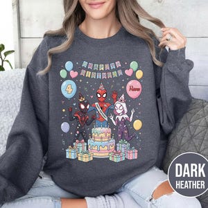 May include: Dark heather gray sweatshirt featuring a colorful birthday design. The graphic includes Spider-Man characters, a cake, balloons, and the words "Happy Birthday." The number "4" is on a balloon. Several wrapped gifts are at the bottom.