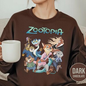 以下が含まれることがあります： アニメ映画「ズートピア」のキャラクターが描かれた、ダークチョコレートブラウンのスウェットシャツ。「ズートピア」の文字はティールとブルーでプリントされています。スウェットシャツはクルーネックと長袖です。