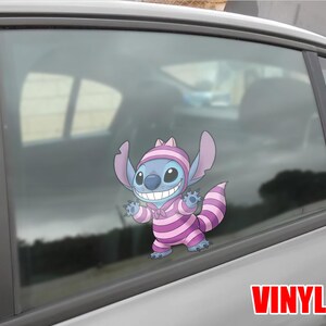 May include: A blue cartoon character sticker, wearing a pink and purple striped outfit and hat, is affixed to a car window. The sticker has the word "VINYL" in red letters at the bottom right.