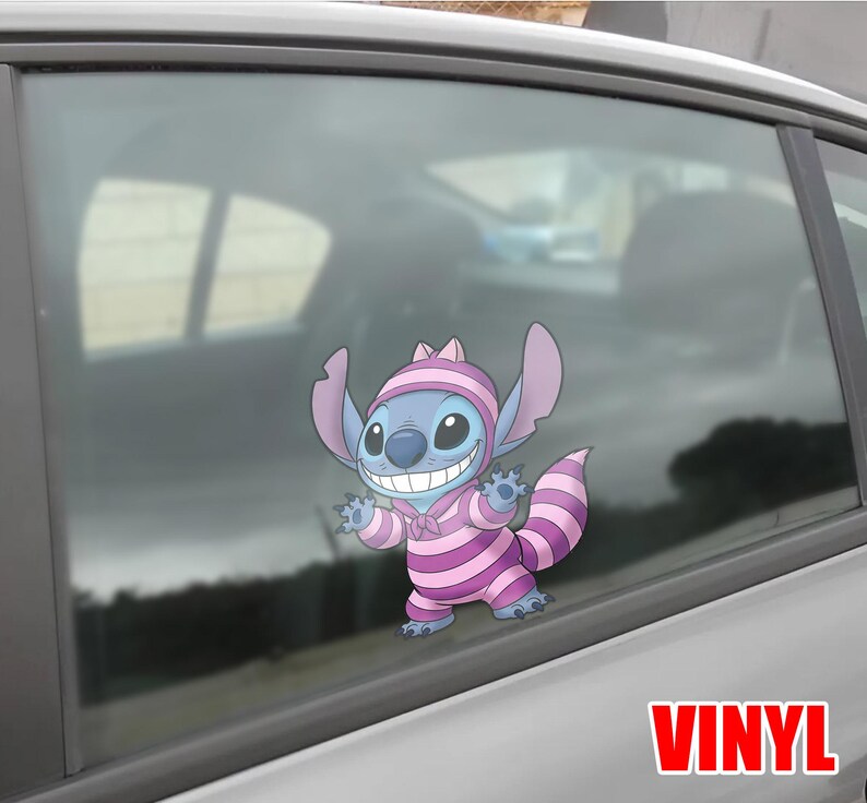 May include: A blue cartoon character sticker, wearing a pink and purple striped outfit and hat, is affixed to a car window. The sticker has the word "VINYL" in red letters at the bottom right.