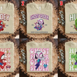 Puede incluir: Camisetas beige con dise&ntilde;os de superh&eacute;roes. Una camiseta presenta "Spidey" con un gr&aacute;fico de Spider-Man, otra dice "Ghost Spider" y la tercera dice "Hulk". Cada camiseta tiene un gr&aacute;fico de superh&eacute;roe diferente.
