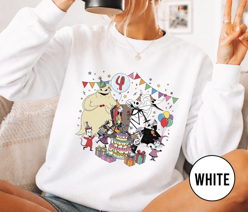 May include: White sweatshirt featuring a colorful cartoon birthday scene with characters, a cake, and the number 4 on a balloon. The word "WHITE" is in a white circle on the bottom right.