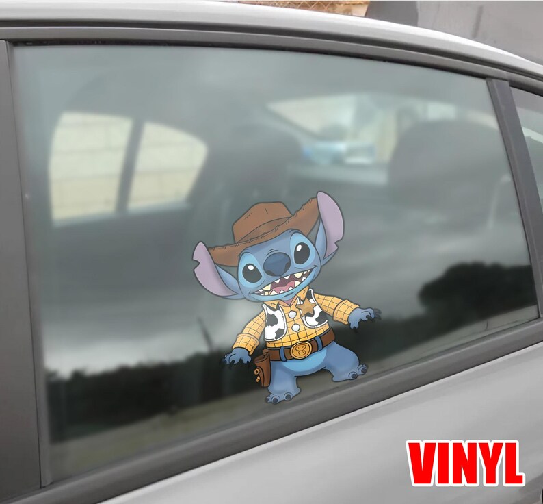 May include: A blue cartoon character wearing a cowboy hat, yellow plaid shirt, and a belt with a gold buckle. The character is a vinyl sticker on a car window. The word "VINYL" is printed in red at the bottom.