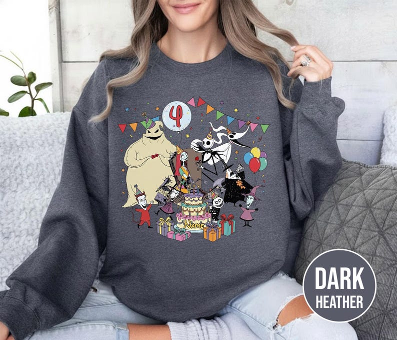 May include: Dark heather gray sweatshirt featuring a colorful graphic of characters from The Nightmare Before Christmas celebrating a birthday. The design includes a birthday cake, presents, and the number 4.