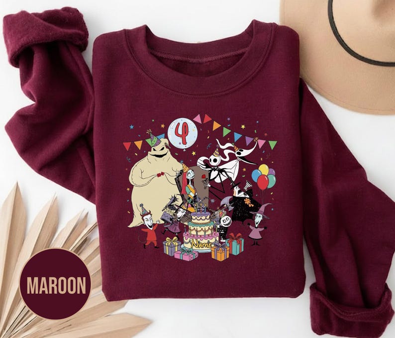 May include: Maroon sweatshirt featuring a colorful graphic of characters from a popular animated film celebrating a birthday. The design includes a birthday cake, presents, and the number 4. The sweatshirt has long sleeves and a crew neck.