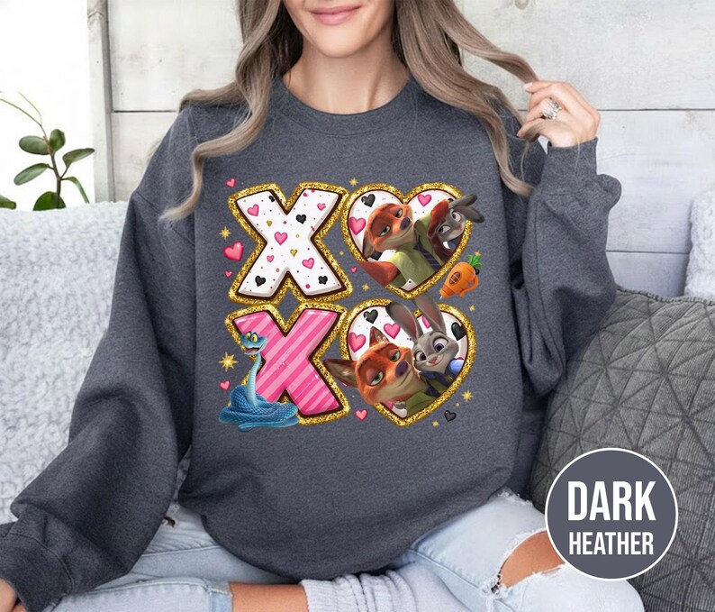 May include: Dark heather gray sweatshirt featuring a graphic design with the letters "XO" and heart-shaped images of cartoon characters. The design includes a snake, a fox, a bunny, and a donkey. The sweatshirt is made of a soft material.