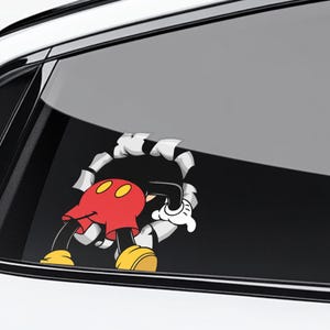 May include: A cartoon decal of Mickey Mouse breaking through a surface. Mickey is wearing red shorts, yellow shoes, and white gloves. The decal is designed to look like Mickey is emerging from a hole.