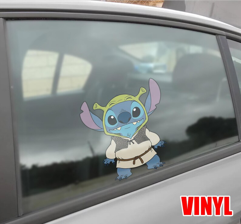 May include: A blue cartoon character wearing a green hat and a tan vest, with a brown belt, is affixed to a car window. The word "VINYL" is printed in red at the bottom right.