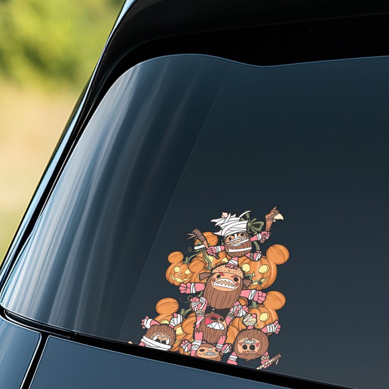 May include: A colorful car decal featuring a cartoon illustration of several characters with pumpkin heads and wrapped in bandages. The characters are holding weapons and are stacked on top of each other. The decal is on a car window.