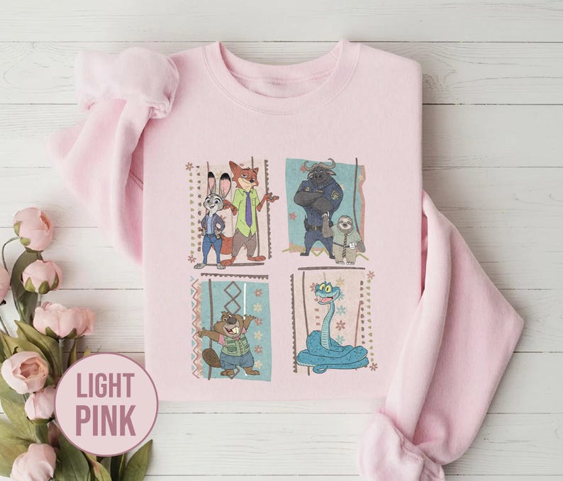 K&ouml;nnte beinhalten: Hellrosa Sweatshirt mit einem farbenfrohen Aufdruck von Charakteren aus dem Animationsfilm Zoomania. Das Design umfasst Judy Hopps, Nick Wilde, Chief Bogo, Flash und andere. Das Sweatshirt ist aus weichem Material.