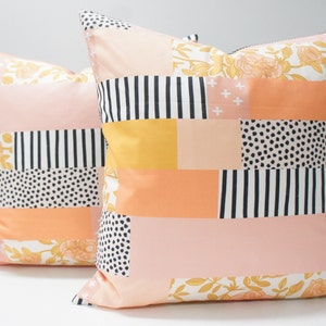 Peut inclure: Deux coussins décoratifs avec un motif patchwork composé de rayures noires et blanches, de pois et de motifs floraux dans des tons de rose, orange et jaune.