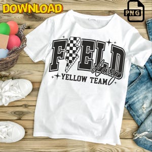 May include: White t-shirt with a black graphic of a checkered lightning bolt and the text "FIELD day YELLOW TEAM".