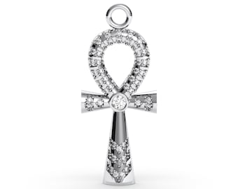 Pode incluir: Um pingente prateado em forma de ankh, um símbolo de vida. O pingente é incrustado com numerosas pedras preciosas pequenas e transparentes, com uma pedra preciosa maior no centro da cruz e do laço. O pingente tem um laço na parte superior para uma corrente.