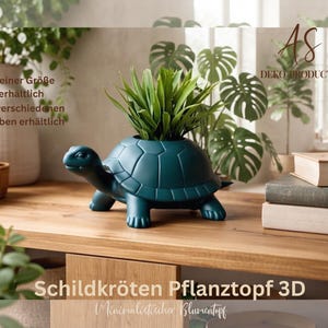 May include: A dark teal turtle-shaped planter with a smooth finish, featuring a hollow shell designed to hold a small green plant. The object is positioned on a wooden surface, with text visible on the image including AS DEKO PRODUCTION and Schildkröten Pflanztopf 3D.