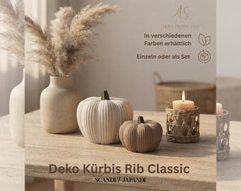 May include: Two ribbed pumpkins in cream and tan, a beige ceramic vase with dried pampas grass, and a lit candle in a woven rattan holder. Text on the image includes Deko Produktion, In verschiedenen Farben erhältlich, Einzeln oder als Set, Deko Kürbis Rib Classic, and Scandi / Japandi.