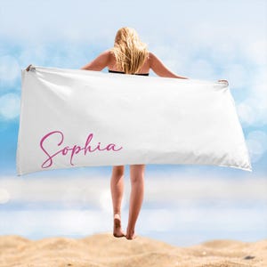 May include: White beach towel with the name "Sophia" written in pink cursive.
