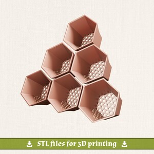 May include: A cluster of six interconnected hexagonal containers in a muted rose color. Each container features a perforated base with a honeycomb pattern. A green banner at the bottom displays the white text: STL files for 3D printing.