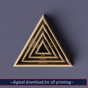 Op de afbeelding: Een gelaagd, geometrisch driehoekontwerp in tinten beige en zwart, tegen een gedempte blauwe achtergrond. Het ontwerp heeft een reeks geneste driehoeken, waardoor een 3D-effect ontstaat. Tekst onderaan luidt "digitale download voor 3D-printen".
