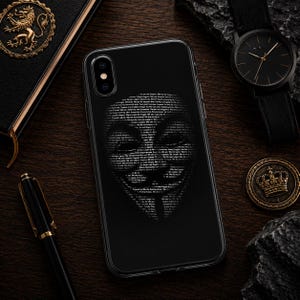 Peut inclure: Une coque de smartphone noire présentant un graphique blanc d'un masque de Guy Fawkes composé entièrement de petits textes répétés. Le motif est centré au dos de la coque, créant un visuel à fort contraste sur le fond noir uni.