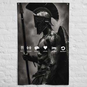 May include: A black and white wall banner featuring a Spartan warrior in a crested helmet holding a spear and shield. The text reads: EAT. TRAIN. STUDY. LOVE. SLEEP. REPEAT. with corresponding icons for each word, set against a cloudy sky background.