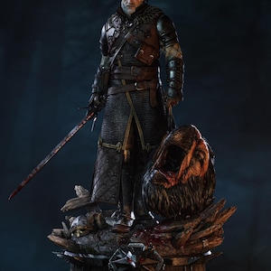 Puede incluir: Estatua detallada de un personaje de la serie The Witcher, de pie sobre una base de madera. La figura está vestida con una armadura oscura y cota de malla, sosteniendo una espada ensangrentada y una cabeza cortada. La base presenta un emblema de lobo y un casco.