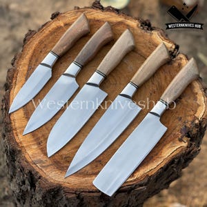 May include: Set of five kitchen knives with wooden handles and silver blades, arranged on a wooden surface. Each knife has a silver bolster and a dark wood handle. The knives are angled towards the viewer. The text "WesternKnives Hub" is visible.