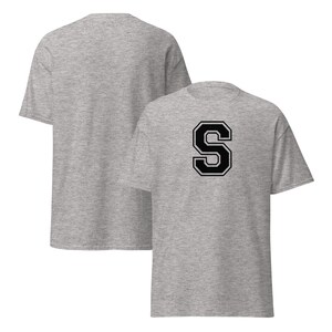 Peut inclure: Deux t-shirts gris chiné. L'un est uni, l'autre présente un grand "S" noir et blanc au dos. Les t-shirts sont faits d'une matière douce et confortable.