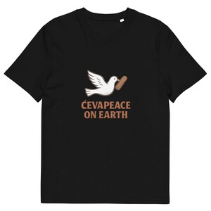 May include: Black t-shirt featuring a white dove carrying a brown sausage. The text "ĆEVAPEACE ON EARTH" is printed below the dove in brown letters. The shirt is made of a soft material.