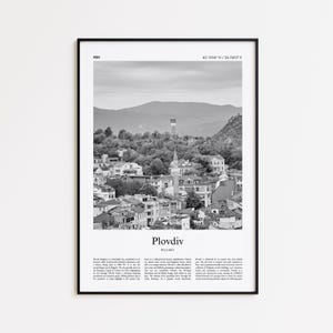May include: Black and white framed print of Plovdiv, Bulgaria. The image features a cityscape with buildings, trees, and a mountain range in the background. The word "Plovdiv" is printed at the bottom.