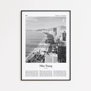 Op de afbeelding: Zwart-wit ingelijste print van Nha Trang, Vietnam. De afbeelding toont een kuststad met een strand, palmbomen en hoge gebouwen. Tekst onderaan luidt "Nha Trang, Vietnam."