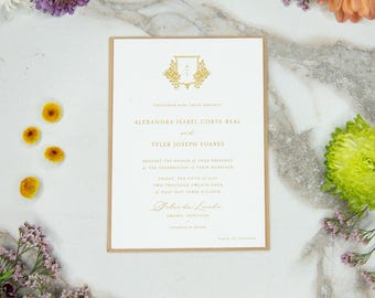 Könnte beinhalten: Eine Hochzeitseinladung mit goldenem Text und einem goldenen Wappen auf weißem Hintergrund, umrahmt von einem beigen Rand. Die Einladung enthält die Namen Alexandra Isabel Corte-Real und Tyler Joseph Soares. Die Einladung ist von bunten Blumen umgeben.