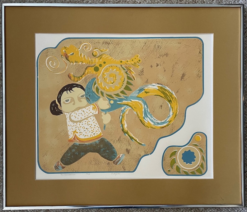 May include: A framed print of a colorful illustration depicting a young person holding a blue and yellow dragon with a swirling tail. The background is a textured tan color.