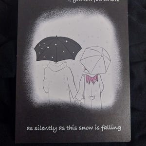 Può includere: Biglietto di auguri in bianco e nero con un'illustrazione di due persone sotto ombrelli nella neve. Il testo recita: "Mi chiedo... Se puoi innamorarti silenziosamente come cade questa neve."
