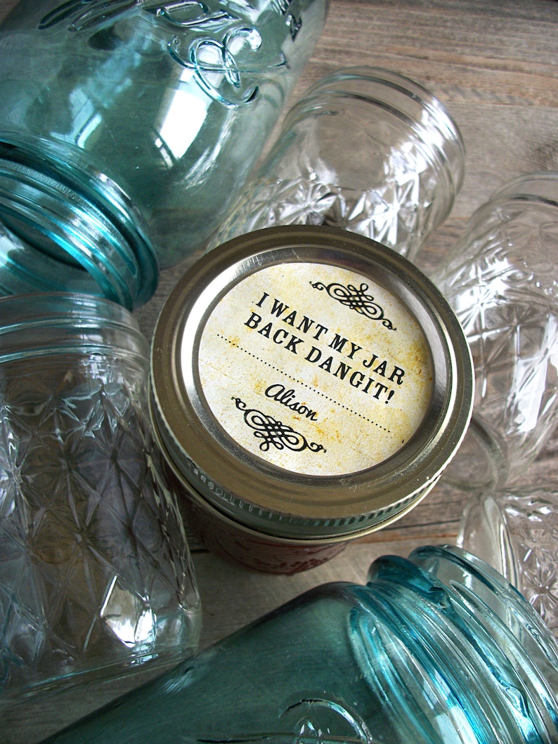 May include: A collection of glass jars with a label on one jar that reads "I want my jar back dangit! Alison".