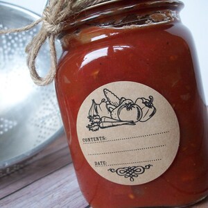 May include: A glass jar with a red sauce inside. The jar has a brown paper label with a black and white illustration of vegetables and the text "CONTENTS: DATE:".