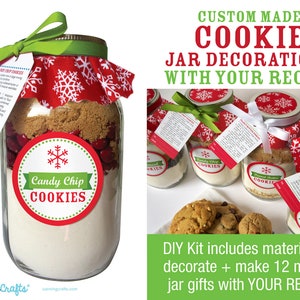 A mason jar filled with cookie ingredients, labeled "Candy Chip Cookies." The jar is adorned with a red and white snowflake fabric lid cover, a green ribbon, and a tag with instructions. The image also shows other jars.